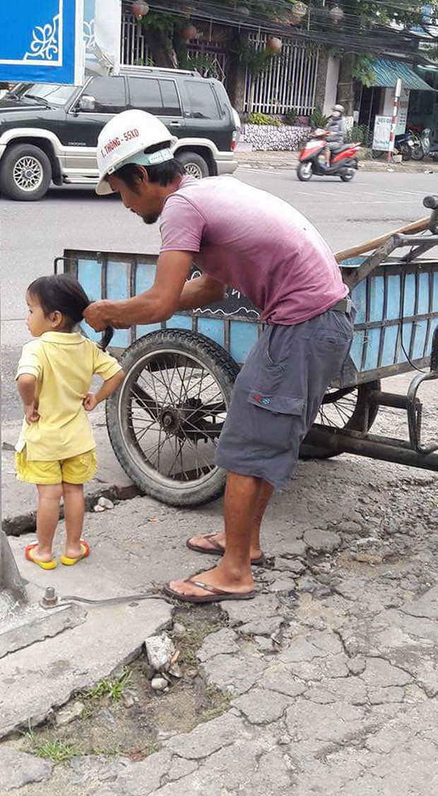Hình ảnh đáng yêu nhất ngày: Người bố công nhân đứng tỉ mẩn cột tóc cho cô con gái nhỏ - Ảnh 1.