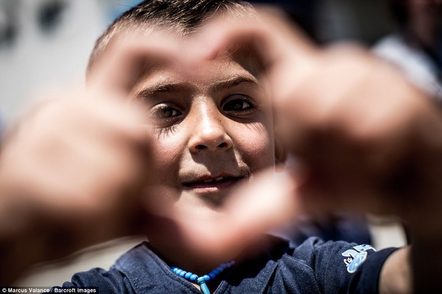 Đằng sau hàng dây thép gai trại tị nạn, vẫn ngời sáng những ánh mắt trẻ thơ an yên, hạnh phúc - Ảnh 1.