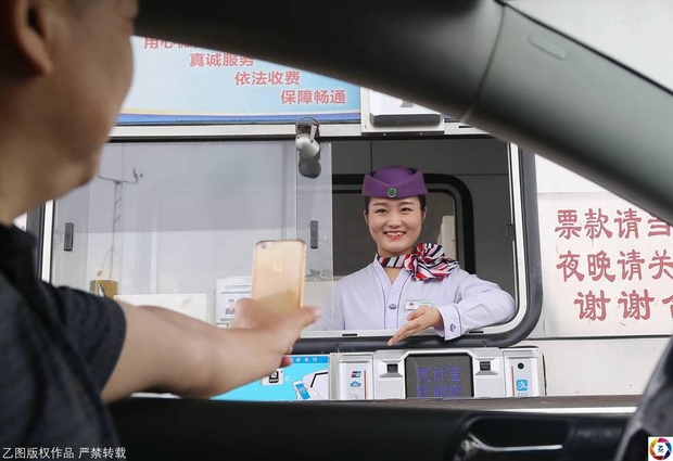 Trung Quốc: Nữ nhân viên soát vé cười đến 8.000 lần/ngày vẫn tươi như hoa, tài xế mong muốn nộp thêm phí - Ảnh 1.