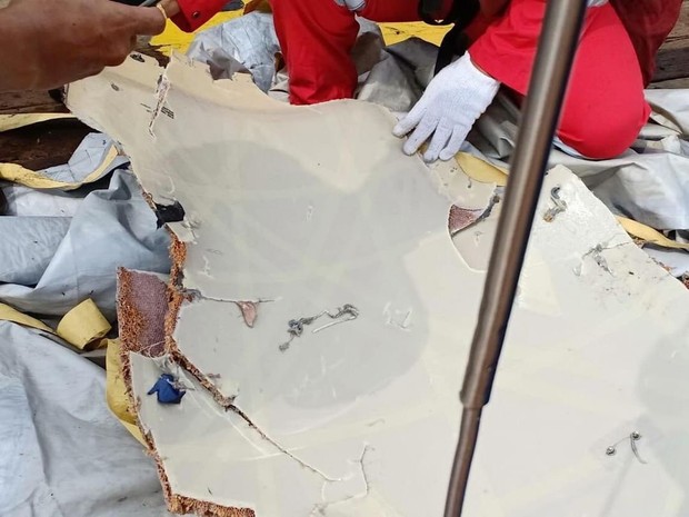Hình ảnh những mảnh vỡ máy bay và đồ đạc của nạn nhân trong vụ tai nạn hàng không tại Indonesia - Ảnh 8.