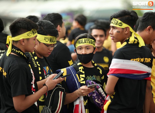 Các cặp đôi nắm tay, đội mưa tới sân Bukit Jalil tiếp lửa cho trận chung kết AFF Cup - Ảnh 1.
