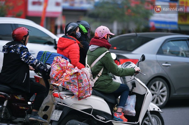 Người dân mang theo hành lí chất trên nóc ô tô, xe máy đổ về Hà Nội và Sài Gòn sau kì nghỉ Tết Nguyên đán kéo dài 1 tuần - Ảnh 3.