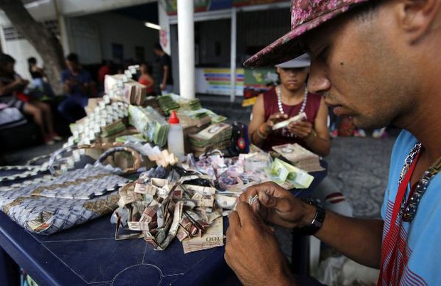 Lạm phát leo thang, người dân Venezuela dùng tiền để gấp đồ thủ công đem bán - Ảnh 1.