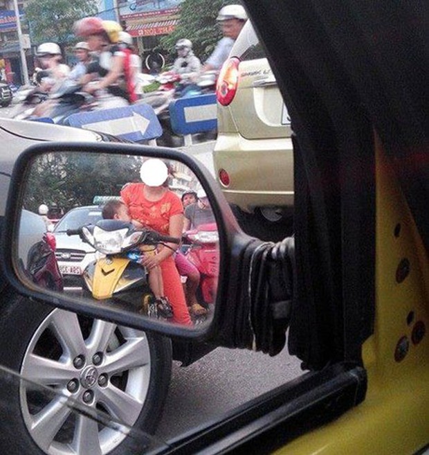 Mẹ trẻ Hà Nội vừa đi xe máy vừa thản nhiên vạch áo cho con bú khiến nhiều người nóng mắt - Ảnh 4. Mẹ trẻ Hà Nội vừa đi xe máy vừa thản nhiên vạch áo cho con bú khiến nhiều người nóng mắt - Ảnh 4.
