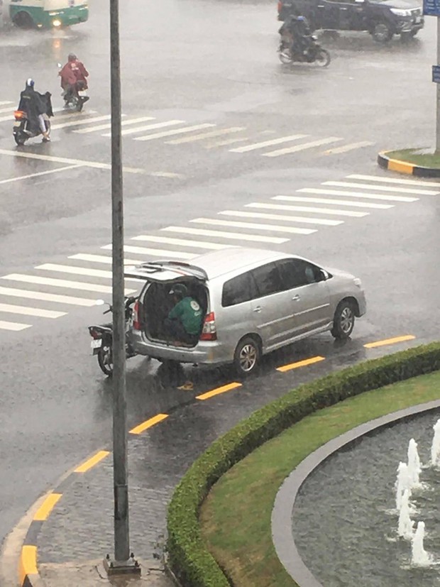 Chiếc ô tô dừng bên góc đường mở cửa cho tài xế xe ôm ngồi trú mưa, hình ảnh đẹp dưới cơn mưa lạnh khiến bao người ấm lòng - Ảnh 1.