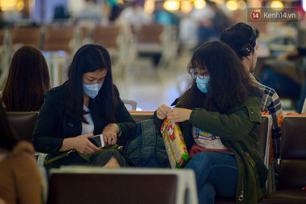 Hành khách đeo khẩu trang kín mít vì lo lắng dịch virus Corona khi chuẩn bị rời sân bay Nội Bài trước thời khắc đón năm mới - Ảnh 5.