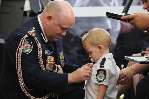 Bé trai 19 tháng tuổi ngậm ti giả nhận huy chương thay người cha đã khuất, hy sinh trong thảm họa cháy rừng ở Úc - Ảnh 1.