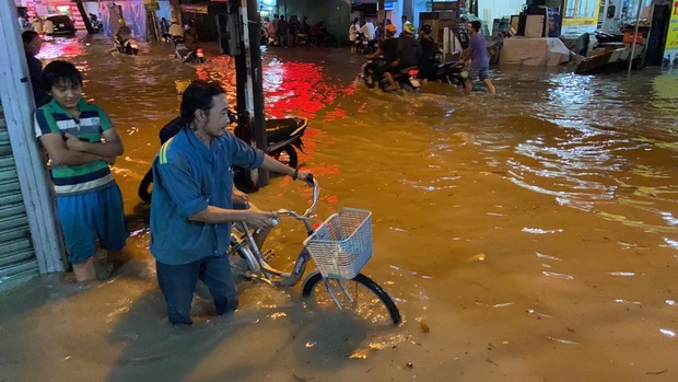 Ảnh: Đường Sài Gòn lại ngập hơn nửa bánh xe, dân vội vã đóng cửa nghỉ bán vì nhà thành hầm chứa nước - Ảnh 6.