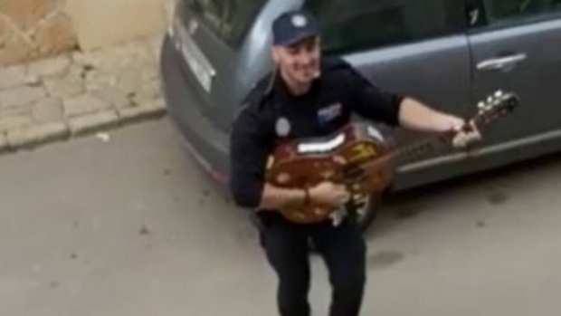 Khoảnh khắc hạnh phúc giữa lúc buồn chán: Anh cảnh sát chơi guitar hát cho cả phố nghe, xua đi bầu không khí u ám vì Covid-19 - Ảnh 2.
