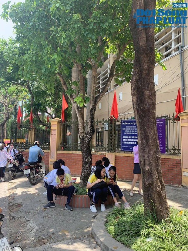 Trường khoá cửa lớp, học sinh Hà Nội đội nắng 40 độ chờ phụ huynh đến đón - Ảnh 2.