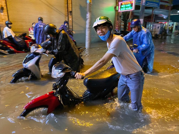 Nhiều tuyến đường Sài Gòn ngập lút bánh xe sau mưa lớn, nước chảy cuồn cuộn như lũ - Ảnh 6.