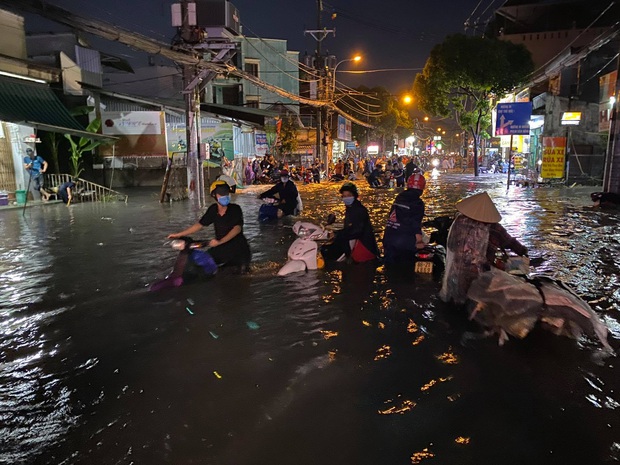 Nhiều tuyến đường Sài Gòn ngập lút bánh xe sau mưa lớn, nước chảy cuồn cuộn như lũ - Ảnh 2.