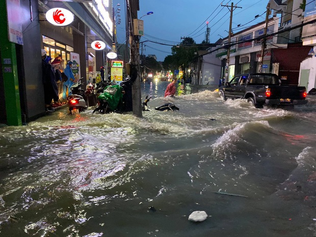Nhiều tuyến đường Sài Gòn ngập lút bánh xe sau mưa lớn, nước chảy cuồn cuộn như lũ - Ảnh 12.