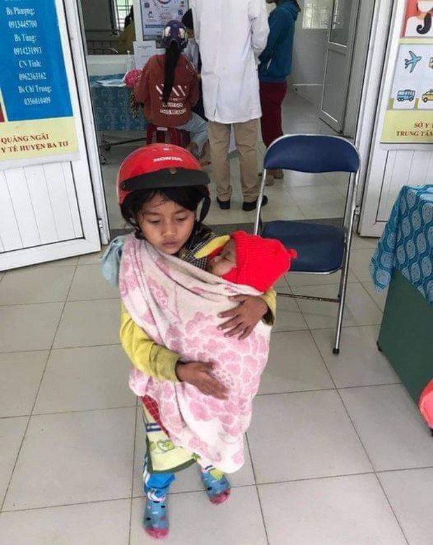 Xót xa hình ảnh bé gái 7 tuổi bế em đi tiêm phòng - Ảnh 1.