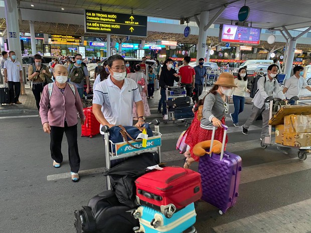 Chùm ảnh: Sân bay Tân Sơn Nhất tấp nập sau kỳ nghỉ Tết Dương lịch, nhiều người xách hành lý lỉnh kỉnh xếp hàng dài - Ảnh 8.