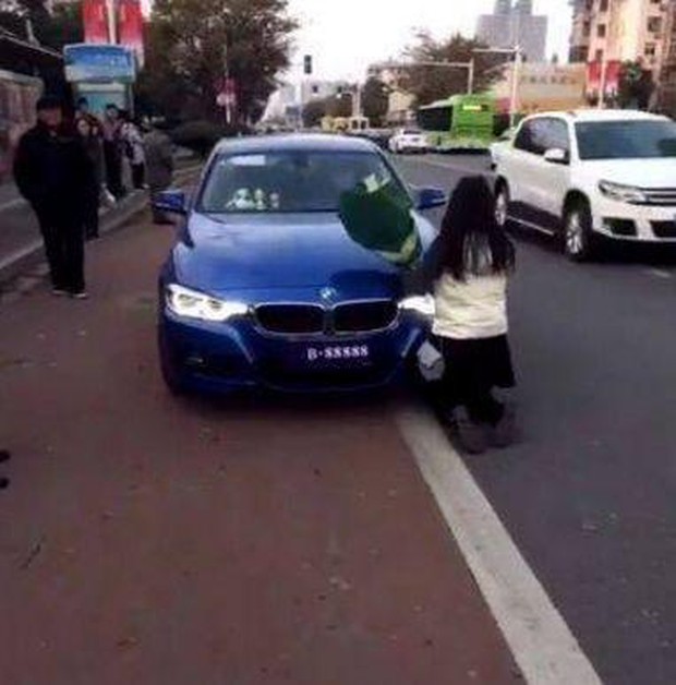 Cô gái quỳ rạp tỏ tình với chàng trai trước đầu xe BMW, hành động của đối phương khiến người đi đường tròn xoe mắt - Ảnh 1.