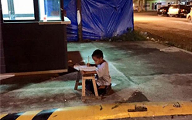 Ngồi học trên vỉa hè dưới ánh điện leo lét, cậu bé nghèo khổ không ngờ bức ảnh vô tình chụp lại đã khiến cuộc đời em rẽ sang hướng khác - Ảnh 1.