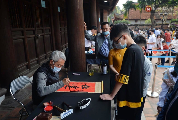 Người dân đeo khẩu trang ùn ùn vào Văn Miếu xin chữ và cầu may đầu năm - Ảnh 5.