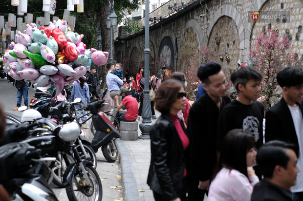 Chùm ảnh: Người dân đeo khẩu trang phòng dịch, xúng xính váy áo xuống phố dạo chơi chiều mùng 2 Tết - Ảnh 8. Chùm ảnh: Người dân đeo khẩu trang phòng dịch, xúng xính váy áo xuống phố dạo chơi chiều mùng 2 Tết - Ảnh 8.