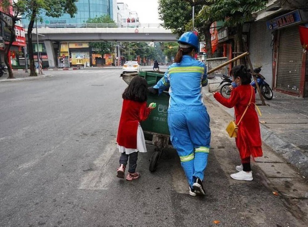 Người mẹ lao công trong bức ảnh cùng 2 con đi làm ngày mùng 1 Tết: Trẻ con thơ ngây lắm, chỉ cần được đi theo mẹ đã thích rồi - Ảnh 1. Người mẹ lao công trong bức ảnh cùng 2 con đi làm ngày mùng 1 Tết: Trẻ con thơ ngây lắm, chỉ cần được đi theo mẹ đã thích rồi - Ảnh 1.