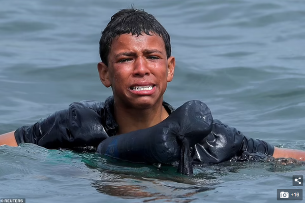 Khoảnh khắc cậu bé di cư bật khóc giữa biển nước mênh mông, dùng chai nhựa để bơi đến miền đất hứa gây chấn động thế giới - Ảnh 2.
