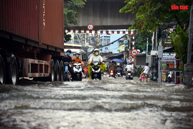 TP Hồ Chí Minh: Triều cường dâng cao, người đi xe máy ngã nhào trong biển nước - Ảnh 4.