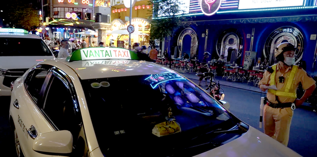 Nhiều taxi “dù” ở trung tâm TP.HCM bị cảnh sát xử lý - Ảnh 1.