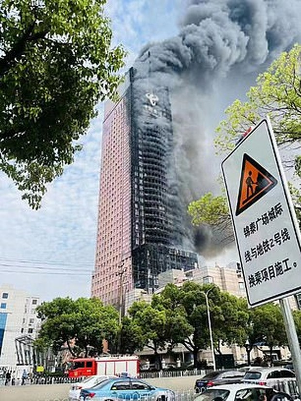 Hình ảnh tòa nhà 42 tầng cháy đen ở Trung Quốc - Ảnh 1.