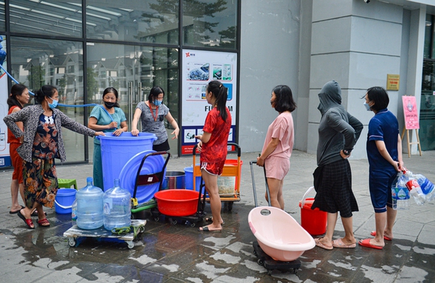 Ảnh: Người dân chung cư Hà Nội mang xô chậu đi lấy nước sạch để rửa bát, tắm gội - Ảnh 2.