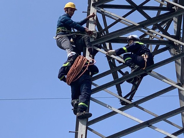 Cứu người phụ nữ 63 tuổi trèo lên cột điện cao 25m ở Hà Nội - Ảnh 1.