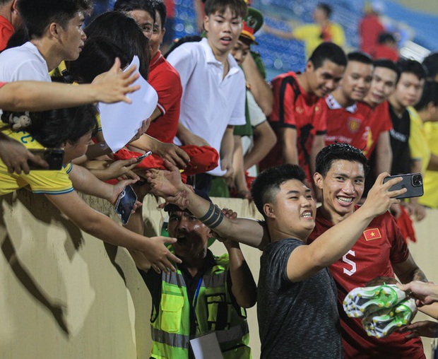 Đội tuyển thủ vui vẻ chấm dứt sân cỏ để ôm chụp ảnh cùng fan hâm mộ sau trận đấu mệt mỏi