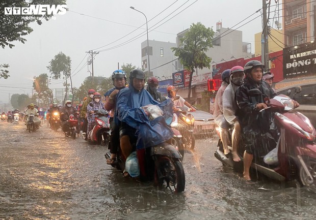 TP.HCM: Đường mênh mông nước, người dân khổ sở về nhà sau cơn mưa lớn - Ảnh 2.