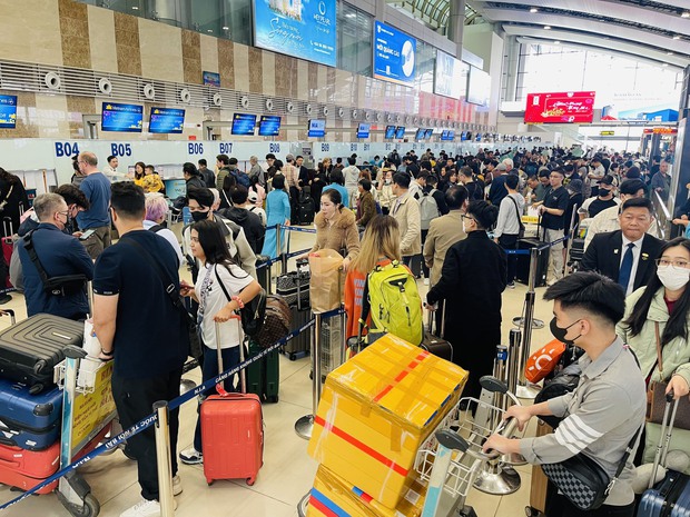 Sân bay Nội Bài đông nghẹt ngày 28 Tết, hành khách vạ vật, nằm ngồi la liệt - Ảnh 1.