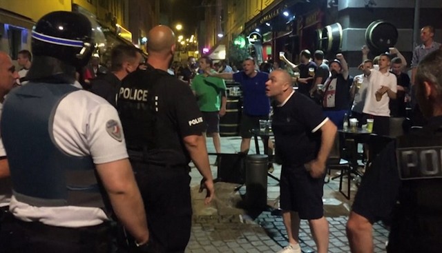 Clash: England fans are captured posturing in front of French police in an aggressive style outside an Irish bar last night