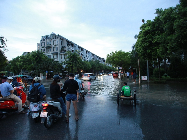 Trời hửng nắng, nhiều tuyến đường ở Hà Nội vẫn ngập sâu, người dân dùng tấm chắn để ngăn nước tràn vào nhà- Ảnh 25.