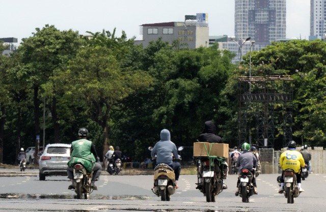 Hà Nội hóa "chảo lửa" giữa trưa 40 độ C: Xuất hiện ảo ảnh trên đường, người dân biến tấu muôn kiểu chống nắng- Ảnh 5.