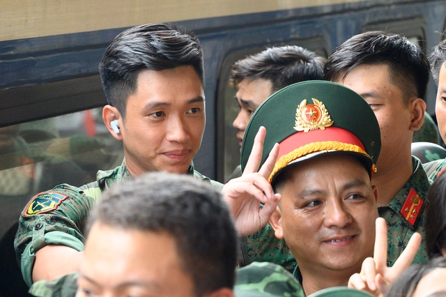 Thượng úy Lê Hoàng Hiệp được các chiến sĩ khác “hộ tống” di chuyển ra khỏi vòng vây của đông đảo người dân tại ga Hà Nội- Ảnh 2.