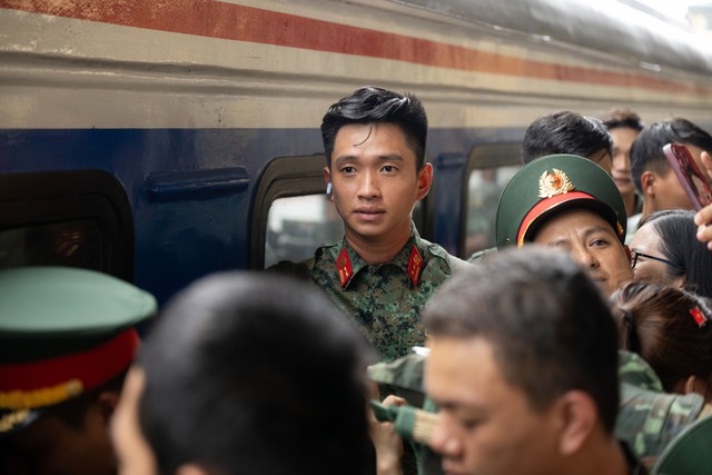 Thượng úy Lê Hoàng Hiệp được các chiến sĩ khác “hộ tống” di chuyển ra khỏi vòng vây của đông đảo người dân tại ga Hà Nội- Ảnh 4.