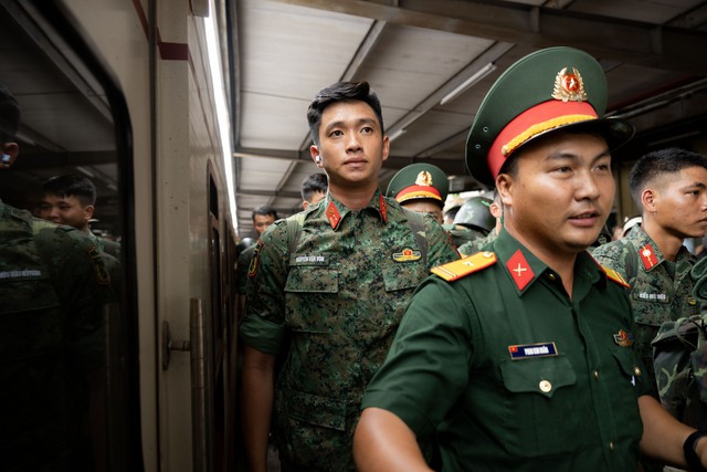 Thượng úy Lê Hoàng Hiệp được các chiến sĩ khác “hộ tống” di chuyển ra khỏi vòng vây của đông đảo người dân tại ga Hà Nội- Ảnh 7.