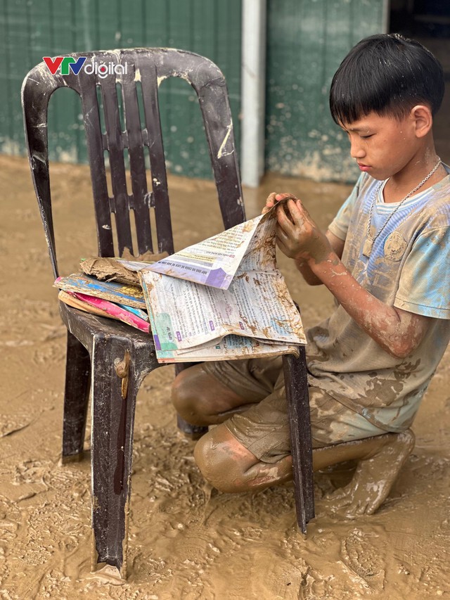 Cậu bé 12 tuổi lật từng trang sách lấm bùn sau lũ quét ở Nghệ An: “Chữ vẫn còn đọc được cô ạ!”- Ảnh 2.