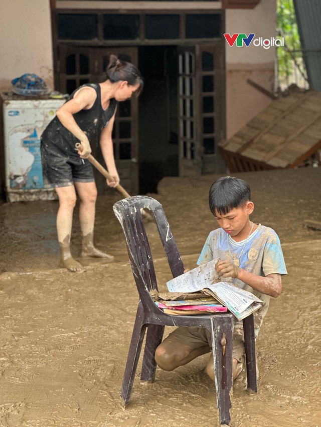 Cậu bé 12 tuổi lật từng trang sách lấm bùn sau lũ quét ở Nghệ An: “Chữ vẫn còn đọc được cô ạ!”- Ảnh 3.