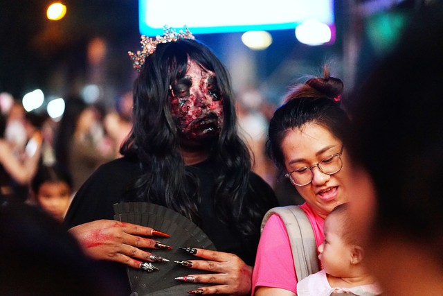 Cả TP.HCM xuống đường tối Halloween, nhiều người kho&aacute;c nguy&ecirc;n &aacute;o mưa xuống phố - Ảnh 4.