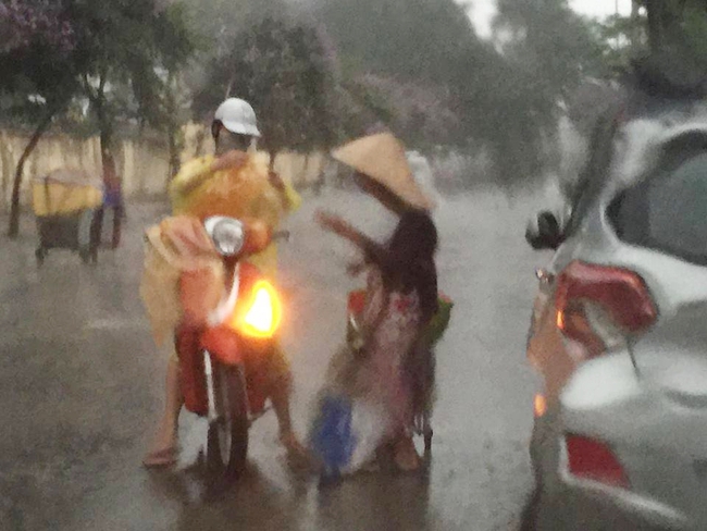 Khoảnh khắc đẹp nhất ngày mưa: Cô gái Hà Nội dừng xe, mặc áo mưa cho cụ bà trong cơn dông - Ảnh 1.