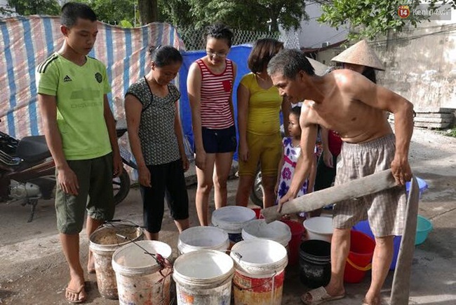 Hà Nội: Người dân xếp hàng chờ đợi lấy từng xô nước sạch giữa ngày nắng nóng - Ảnh 1.