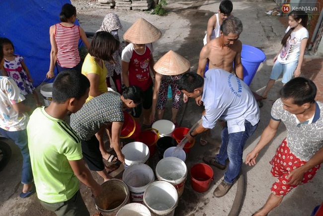 Hà Nội: Người dân xếp hàng chờ đợi lấy từng xô nước sạch giữa ngày nắng nóng - Ảnh 2.