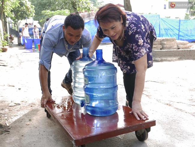 Hà Nội: Người dân xếp hàng chờ đợi lấy từng xô nước sạch giữa ngày nắng nóng - Ảnh 7.