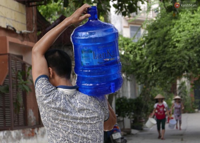 Hà Nội: Người dân xếp hàng chờ đợi lấy từng xô nước sạch giữa ngày nắng nóng - Ảnh 8.