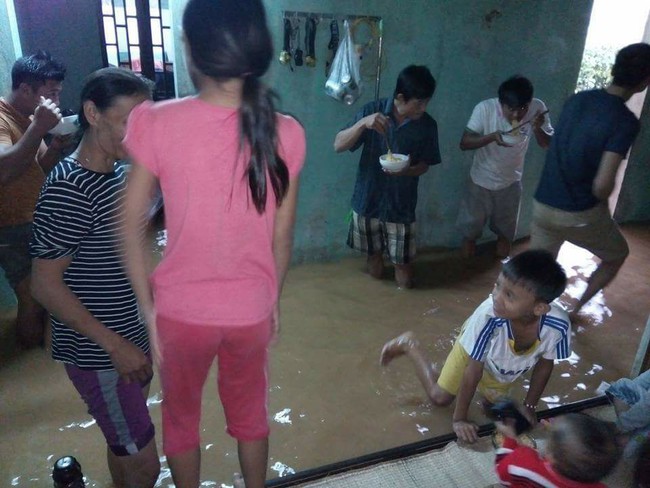 Bức ảnh cả gia đình đứng ăn mì tôm trong ngôi nhà ngập ở Quảng Bình khiến nhiều người xót xa - Ảnh 1.