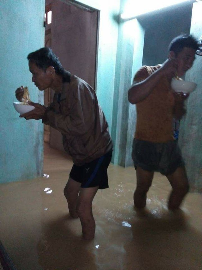 Bức ảnh cả gia đình đứng ăn mì tôm trong ngôi nhà ngập ở Quảng Bình khiến nhiều người xót xa - Ảnh 2.