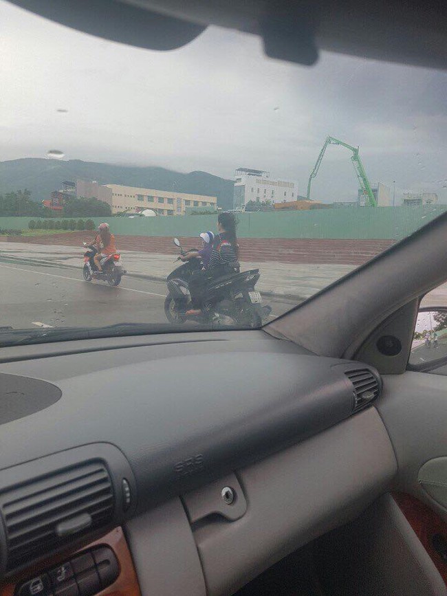 Thót tim cảnh bé trai lái xe máy chở theo một cô gái không đội mũ bảo hiểm trên đường - Ảnh 1.